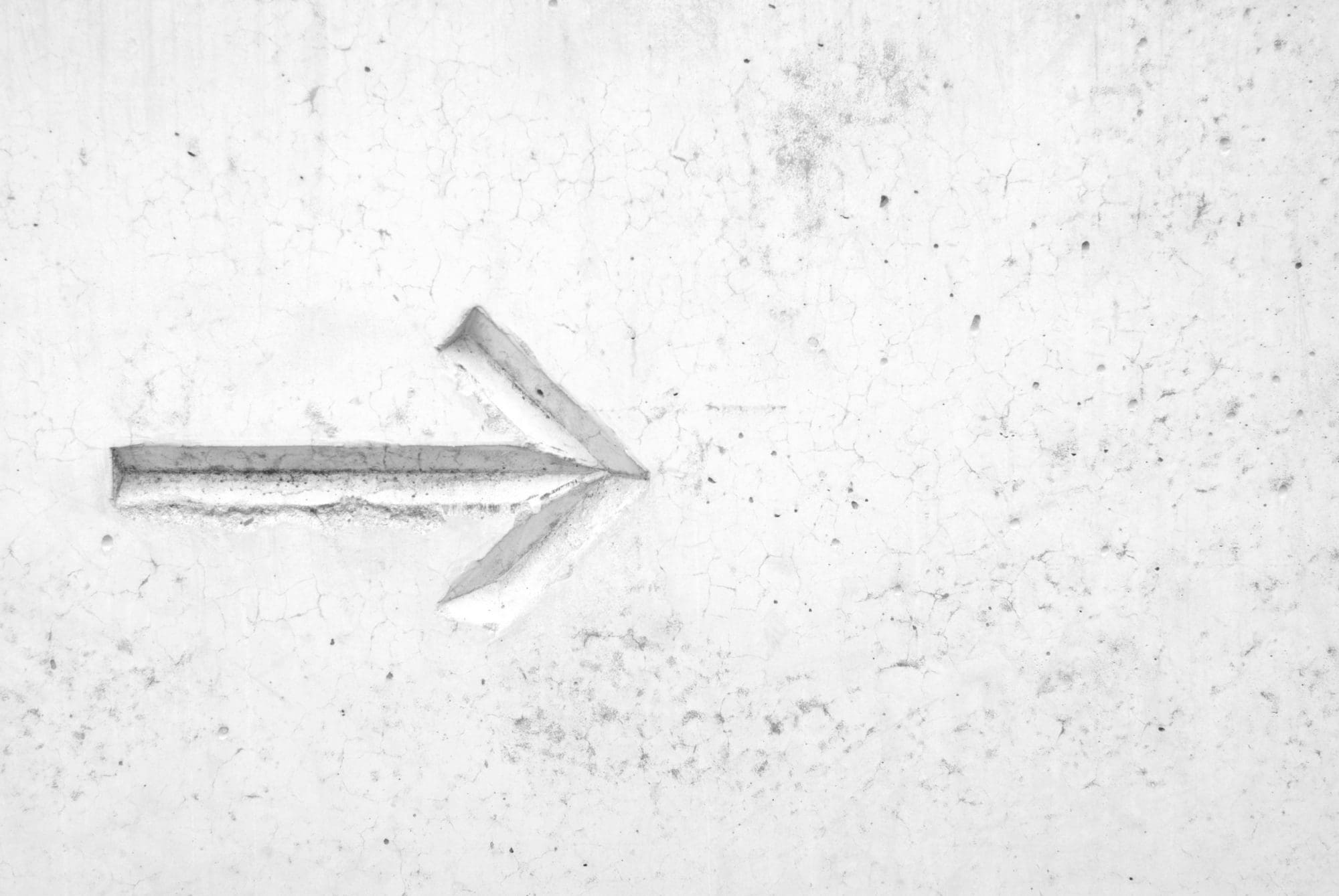 indented white arrow on white marble background