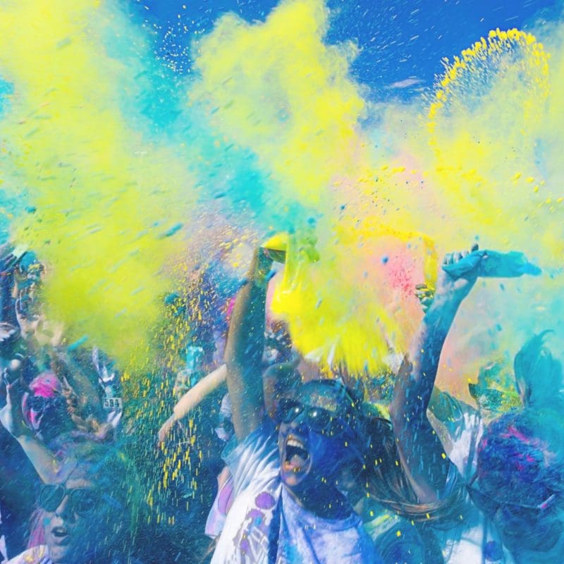 people throwing coloured powder into the air