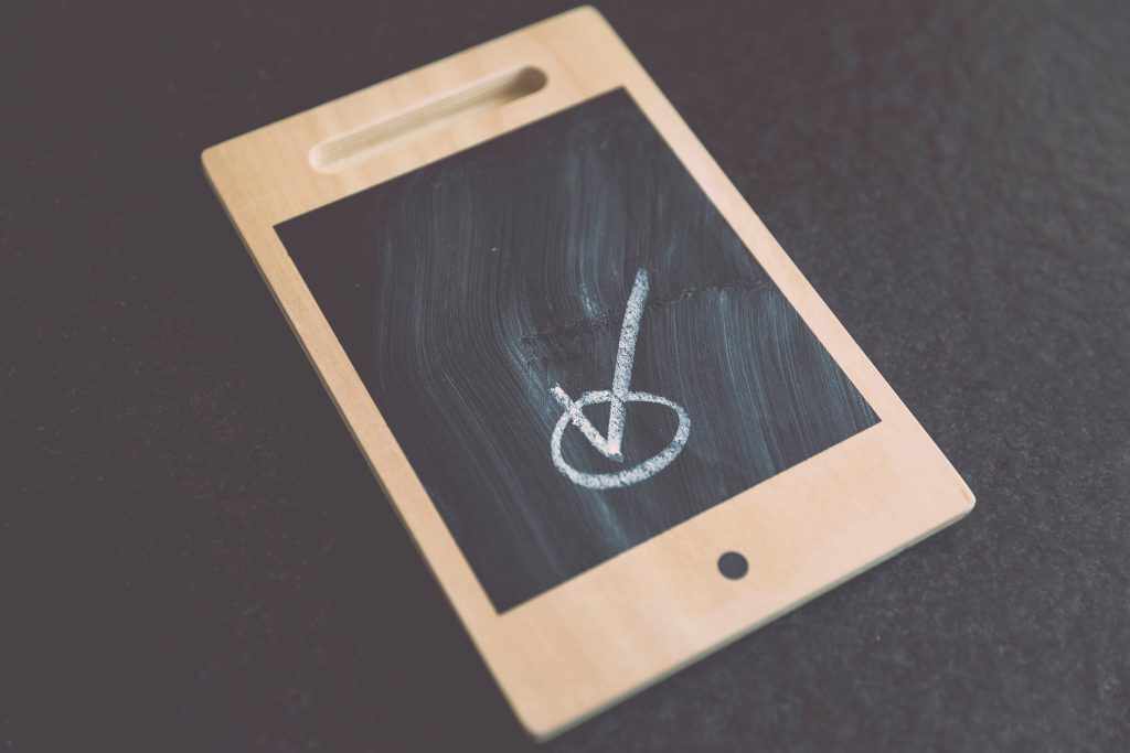 mobile tablet with a tick in a circle drawn in chalk